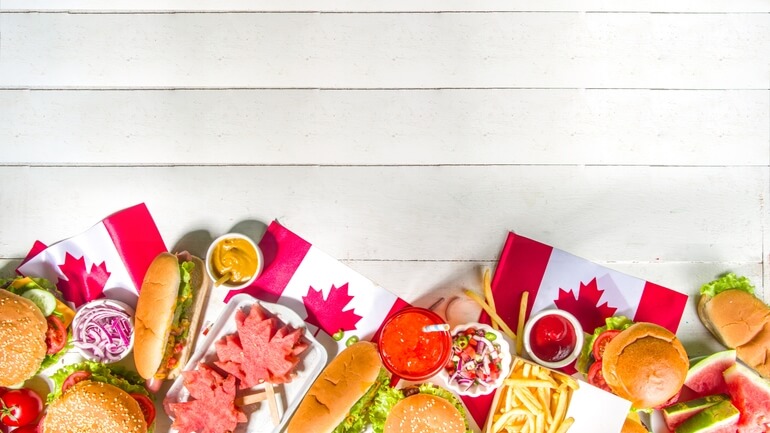 Canada Day themed foods like burgers, hot dogs, fries, and ice cream with red and white colors, Canada flags, and maple leafs