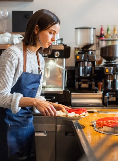 Image of a bakery employee cutting pastry