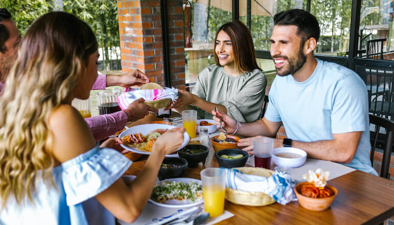 Group of friends enjoying Mexican food on a restaurant patio.