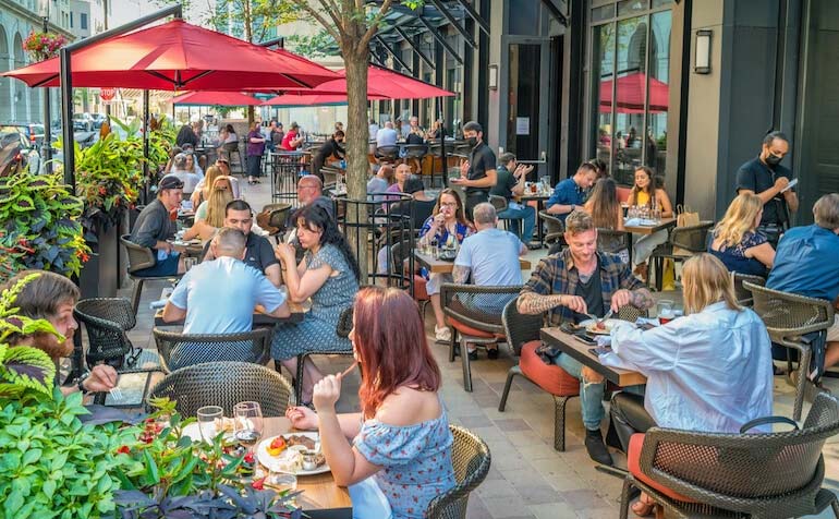 People dining on a busy restaurant patio.