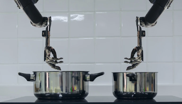 Robot hands stir pots on a stove.