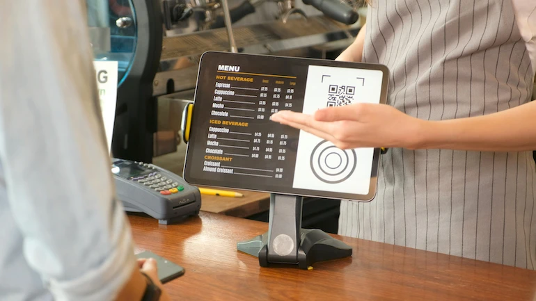 Server showing diner a customer facing display with menu items.