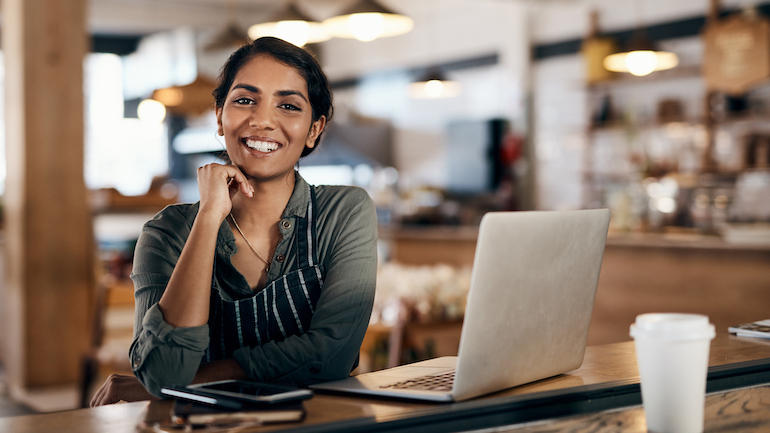 Shot of a young woman using a laptop while working in a cafe.