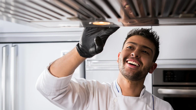 Latin American chef aged between 25-35 years is cleaning the kitchen before cooking