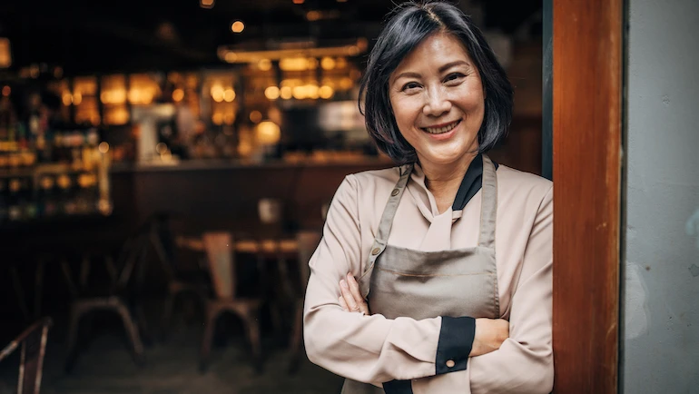 Woman standing at small business cafe/restaurant/coffee shop.