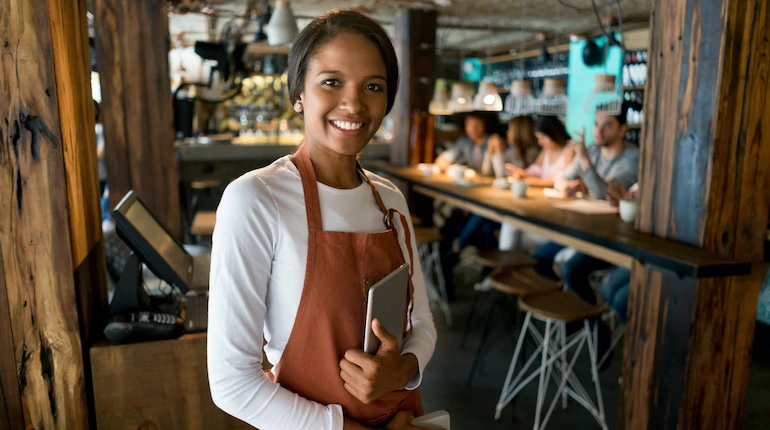 Waitress working at a restaurant and holding an iPad tablet.