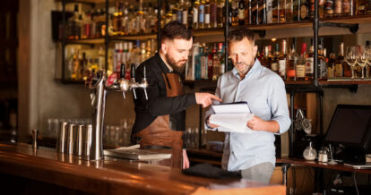 Shot of a bar manager and bartender checking the stock in the pub