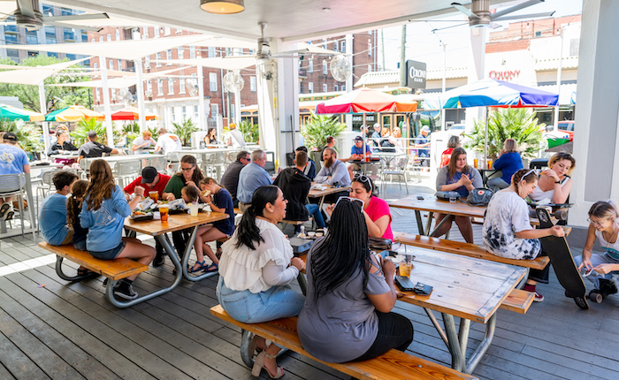 People eating on a busy patio at Zunzi's restaurant.