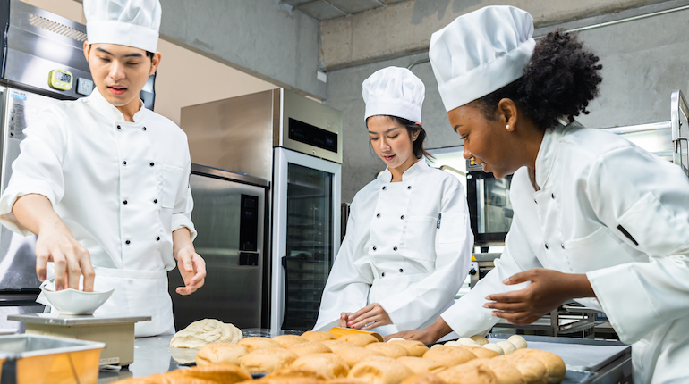 Chef baker in a chef dress and hat, cooking together in kitchen