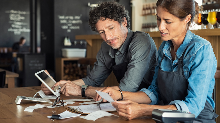 Man and woman sitting in a restaurant discussing finance for the for the month. 