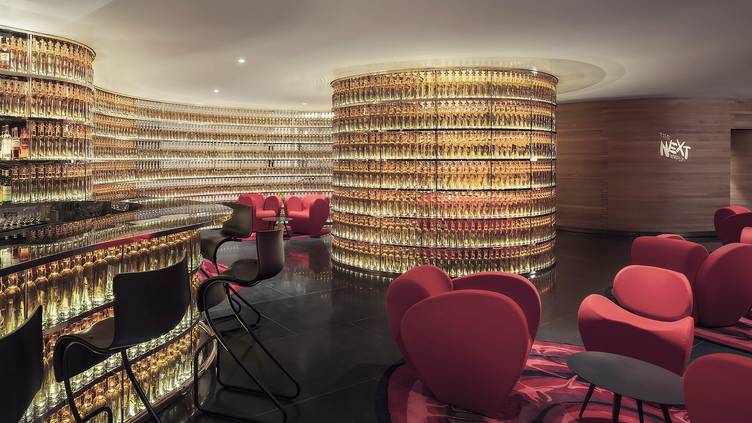 A modern bar at the Watergate Hotel in Washington, D.C., which features walls made up of backlighted whisky bottles.