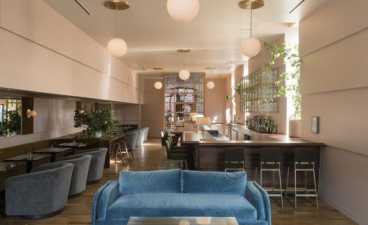 A pastel hued bar in Tulsa, Oklahoma with a soft blue couch in the middle of the room.