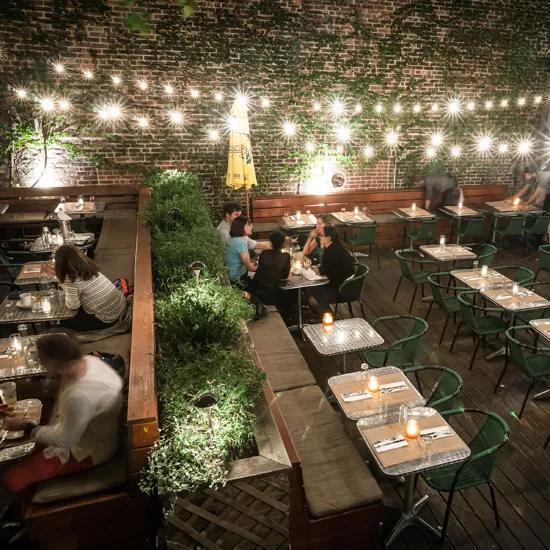 Brooklyn's Gran Eléctrica patio all lit up at night with strong lights.