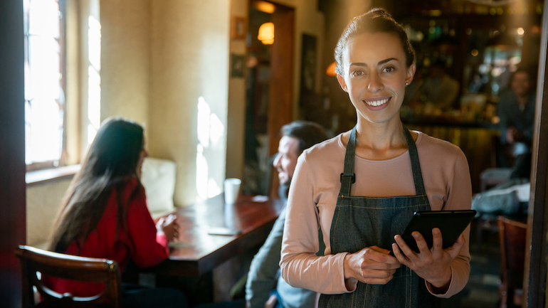 Restaurant worker holding a tablet in a restaurant.