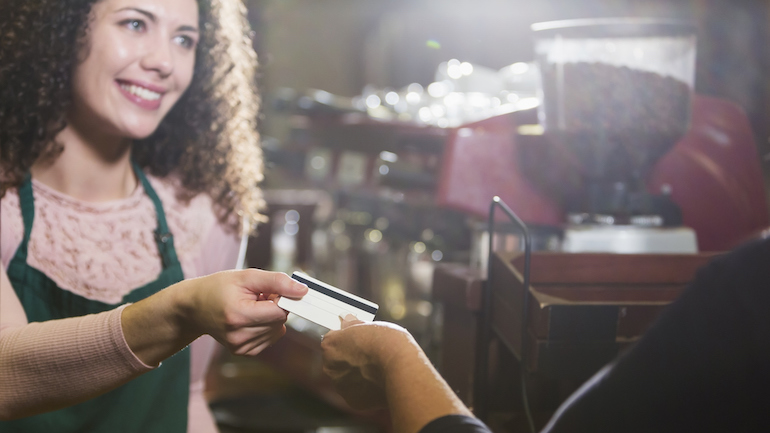 Customer handing restaurant worker a gift card.