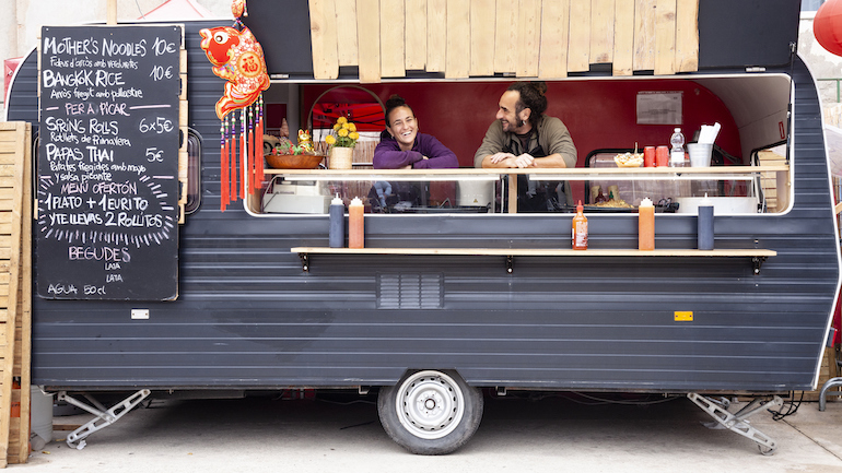 Two people inside a food truck working.