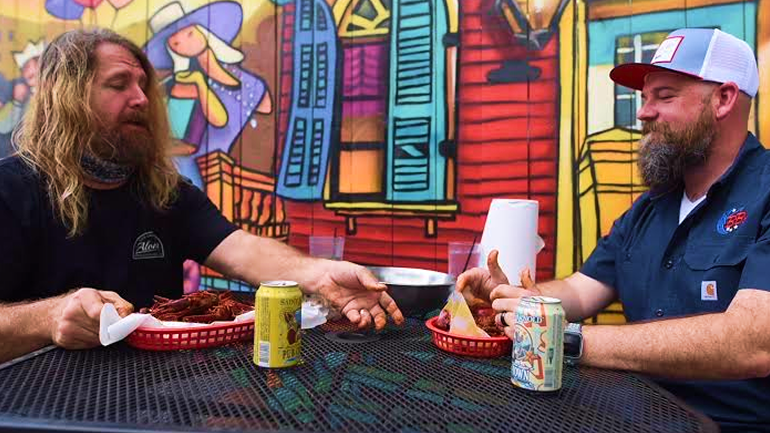 Image of Adam, BB's Vice President of Food and Beverage Operations sitting at a table outside enjoying a meal with another person.